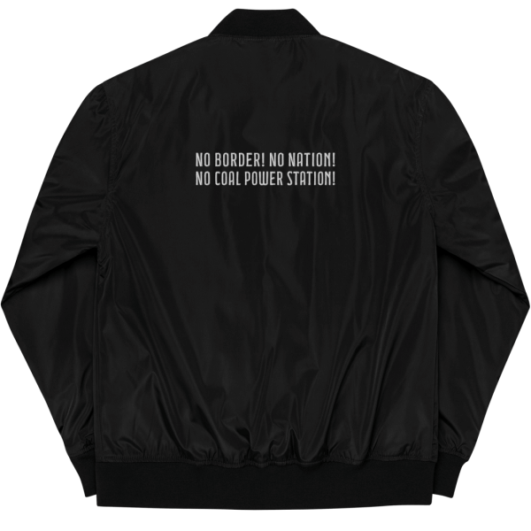 Backside of a black bomber jacket supporting antifascist climate activists, made of recycling polyester, on the upper back of the bomber jacket, there is a white embroidery saying 'No border! No nation! No coal power station!'