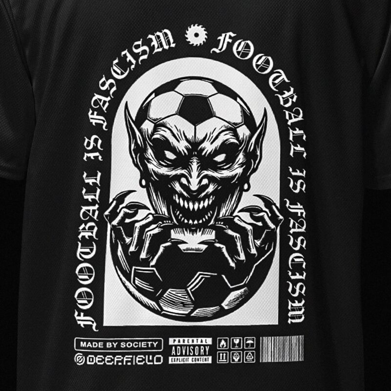 Closeup view of black anti football shirt with white print, it has the words 'Football is Fascism' printed on it's back, along with an illustration of an evil creature, evolving out of a football. Below there are several arbitrary icons.